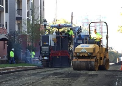 cold weather asphalt Workers operating heavy machinery to pave a road in a residential area of Charlotte, NC.
